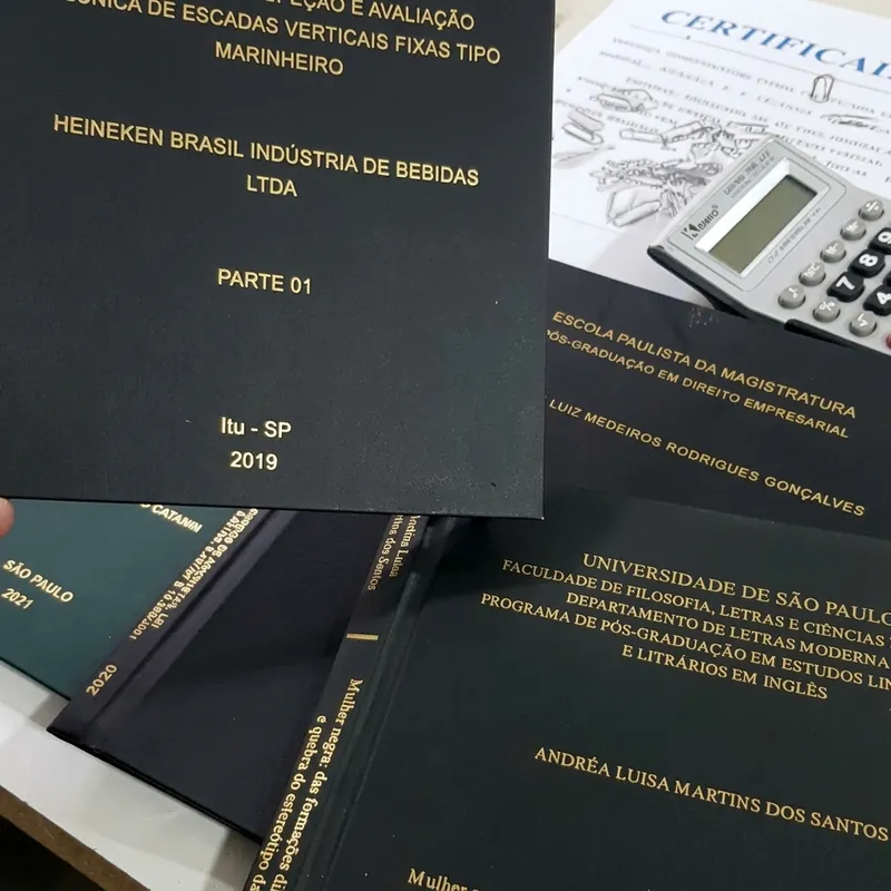 Trabalhos acadêmicos com encadernação em capa dura e gravação dourada